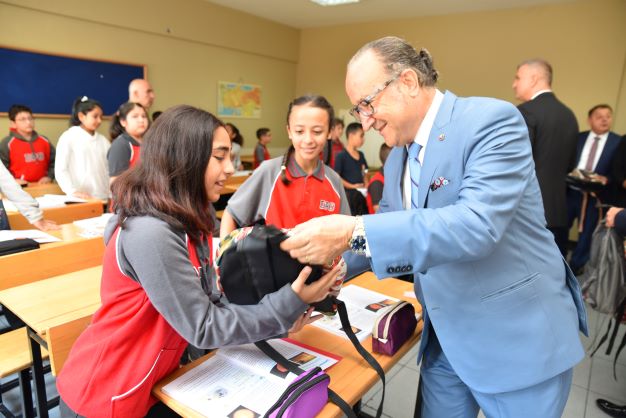 KSO Başkanı Ayhan Zeytinoğlu ve protokol üyeleri, öğrencilere içlerinde kırtasiye malzemeleri olan okul çantalarını dağıttı.